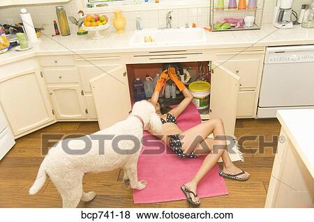 Woman in bikini fixing plumbing under sink View Large Photo Image Stock Photo - Woman in bikini fixing plumbing under sink. Fotosearch