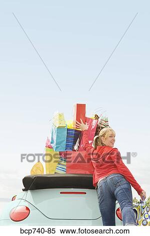 Woman reaching for shopping bag stack in car View Large Photo Image Stock Photography - Woman reaching for shopping bag stack in car. Fotosearch