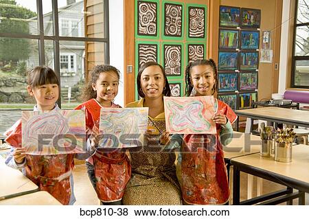 Stock Photo - African art teacher and students holding paintings. Fotosearch
