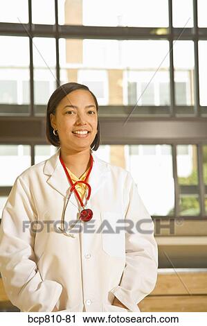 Stock Image - African female doctor with hands in pockets. Fotosearch