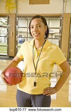 African female gym teacher holding ball View Large Photo Image Stock Photo - African female gym teacher holding ball. Fotosearch