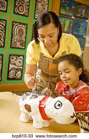 African female teacher helping student with art project View Large Photo Image Stock Image - African female teacher helping student with art project. Fotosearch