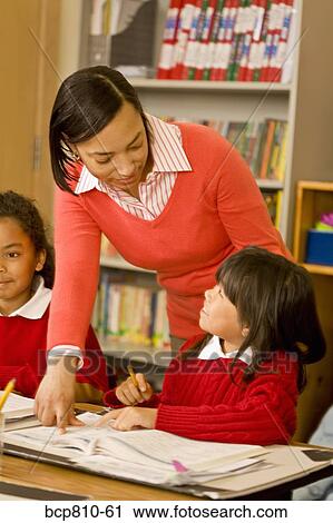 Stock Image - African female teacher helping student. Fotosearch