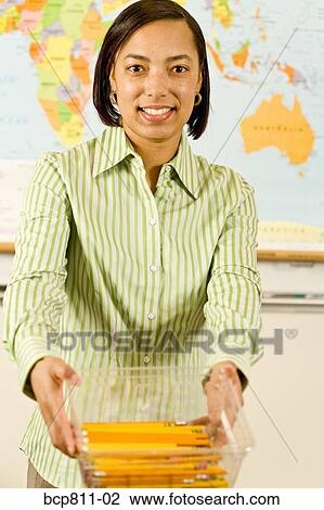 African female teacher holding bin of pencils View Large Photo Image Stock Image - African female teacher holding bin of pencils. Fotosearch