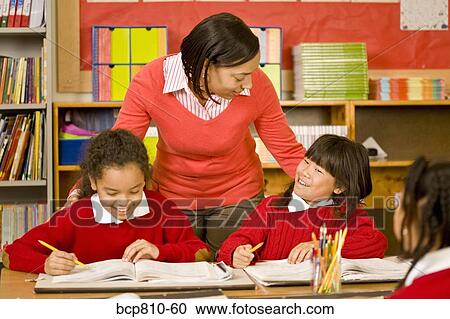 Stock Image - African female teacher talking to students. Fotosearch