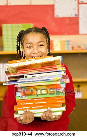 African girl carrying stack of school books View Large Photo Image Picture - African girl carrying stack of school books. Fotosearch