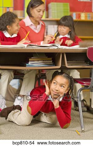 African girl sitting under school desk View Large Photo Image Picture - African girl sitting under school desk. Fotosearch
