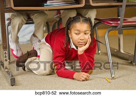 African girl sitting under school desk View Large Photo Image Stock Image - African girl sitting under school desk. Fotosearch