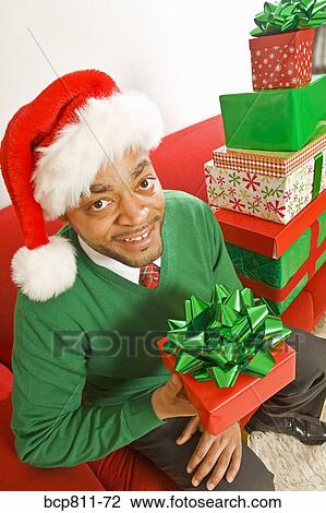 African man holding Christmas gift View Large Photo Image Stock Image - African man holding Christmas gift. Fotosearch