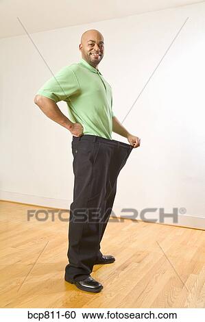 African man holding out waistband of big pants View Large Photo Image Stock Image - African man holding out waistband of big pants. Fotosearch