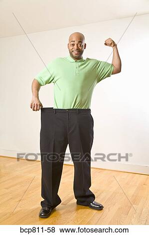African man holding out waistband of big pants View Large Photo Image Stock Photo - African man holding out waistband of big pants. Fotosearch
