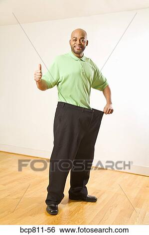 African man holding out waistband of big pants View Large Photo Image Stock Photograph - African man holding out waistband of big pants. Fotosearch