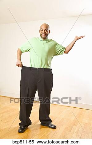 African man holding out waistband of big pants View Large Photo Image Stock Photography - African man holding out waistband of big pants. Fotosearch