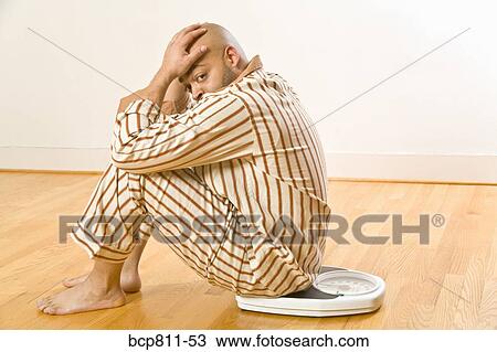 African man sitting on scale View Large Photo Image Stock Image - African man sitting on scale. Fotosearch