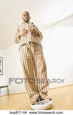 African man standing on scale View Large Photo Image Picture - African man standing on scale. Fotosearch