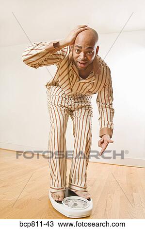 African man standing on scale View Large Photo Image Stock Image - African man standing on scale. Fotosearch