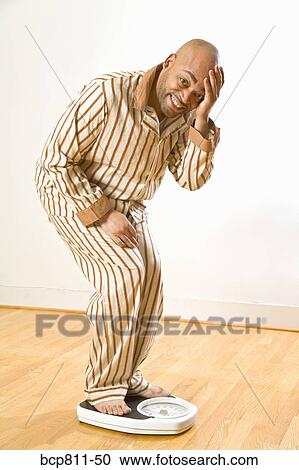 African man standing on scale View Large Photo Image Stock Image - African man standing on scale. Fotosearch