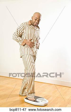 African man stepping onto scale View Large Photo Image Stock Photo - African man stepping onto scale. Fotosearch