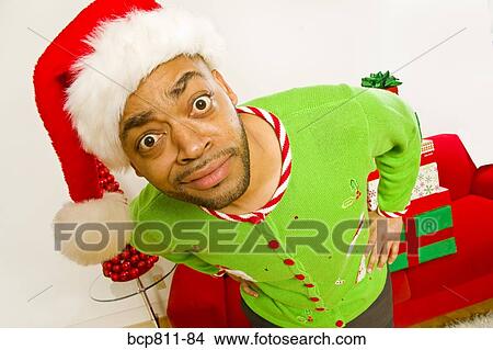 Picture - African man wearing Santa Claus hat. Fotosearch