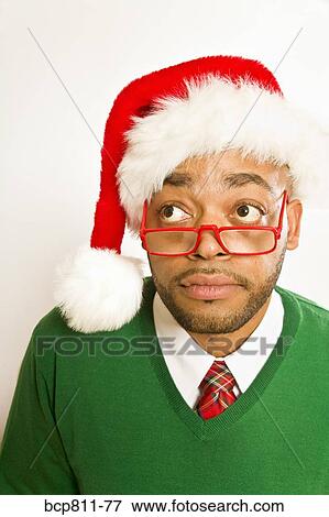 Stock Photo - African man wearing Santa Claus hat. Fotosearch