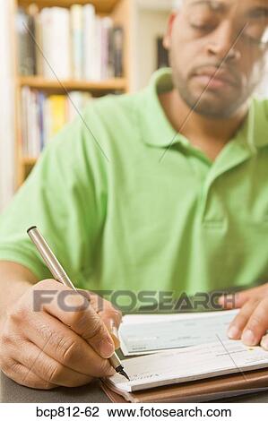 Stock Image - African man writing check. Fotosearch