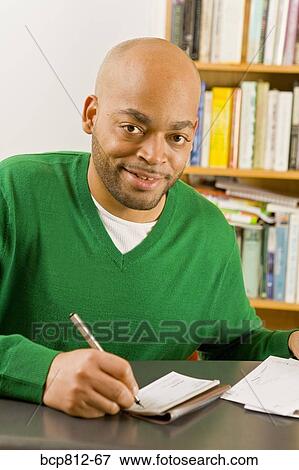 Stock Photo - African man writing check. Fotosearch