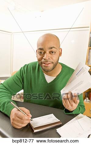 Stock Photo - African man writing check. Fotosearch