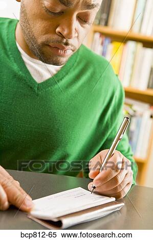 Stock Photography - African man writing check. Fotosearch