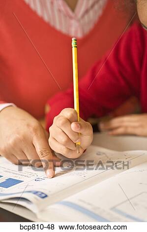 Stock Photo - African mother helping daughter with homework. Fotosearch