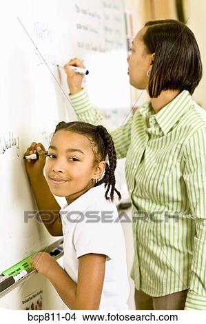African teacher and student writing on whiteboard View Large Photo Image Picture - African teacher and student writing on whiteboard. Fotosearch