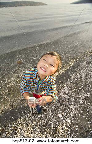 Asian boy holding seashell View Large Photo Image Stock Image - Asian boy holding seashell. Fotosearch
