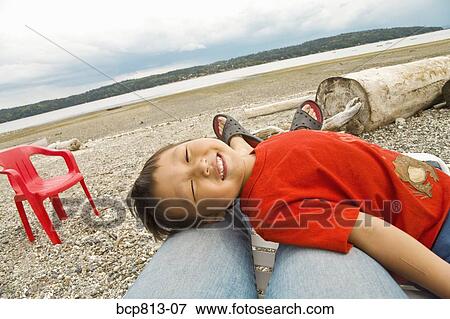 Asian boy lying on mother’s legs View Large Photo Image Stock Photo - Asian boy lying on mother’s legs. Fotosearch