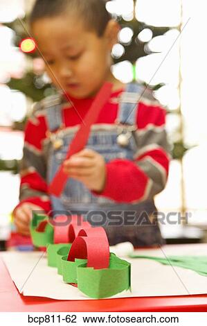 Asian boy making paper chain View Large Photo Image Stock Image - Asian boy making paper chain. Fotosearch