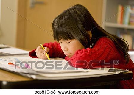 Stock Photo - Asian girl doing school work. Fotosearch