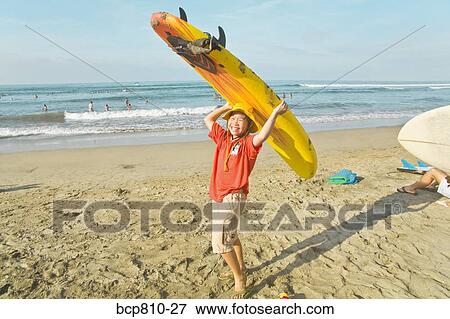 Asian girl holding surfboard on head View Large Photo Image Stock Photo - Asian girl holding surfboard on head. Fotosearch