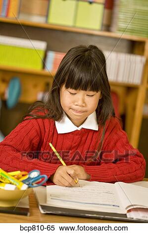 Asian girl writing at school desk View Large Photo Image Stock Photography - Asian girl writing at school desk. Fotosearch
