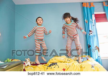 Asian siblings jumping on bed View Large Photo Image Stock Image - Asian siblings jumping on bed. Fotosearch