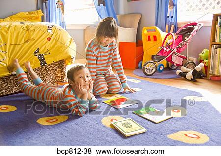 Asian siblings sitting on floor with books View Large Photo Image Stock Photo - Asian siblings sitting on floor with books. Fotosearch