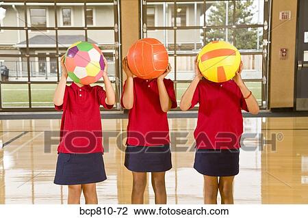 Stock Image - Multi-ethnic girls holding sports balls. Fotosearch