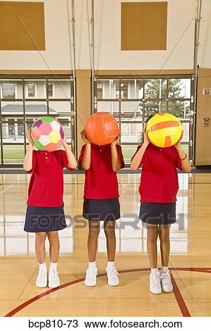 Stock Image - Multi-ethnic girls holding sports balls. Fotosearch