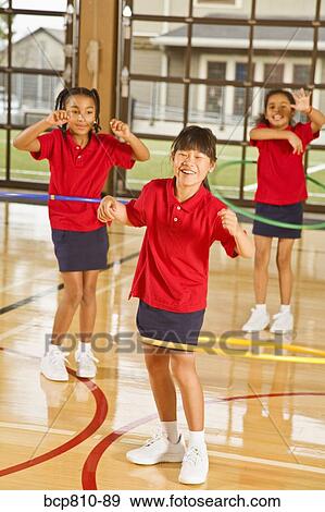Stock Photo - Multi-ethnic girls playing with hula hoops. Fotosearch