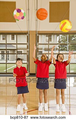 Multi-ethnic girls throwing sports balls View Large Photo Image Stock Photo - Multi-ethnic girls throwing sports balls. Fotosearch