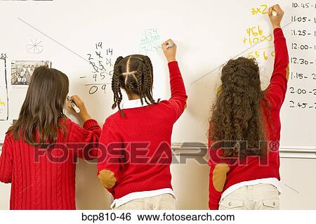 Stock Photograph - Multi-ethnic girls writing in whiteboard. Fotosearch