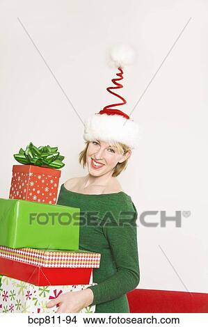 Woman carrying stack of Christmas gifts View Large Photo Image Picture - Woman carrying stack of Christmas gifts. Fotosearch