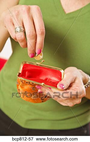 Woman dropping coin in purse View Large Photo Image Stock Photo - Woman dropping coin in purse. Fotosearch