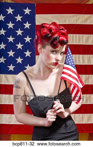 Stock Image - Woman holding American flag. Fotosearch