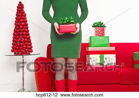Stock Image - Woman holding Christmas gift. Fotosearch