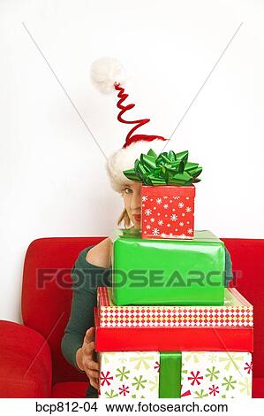Woman holding stack of Christmas gifts View Large Photo Image Picture - Woman holding stack of Christmas gifts. Fotosearch