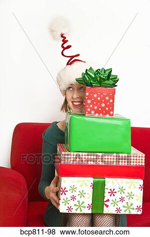 Woman holding stack of Christmas gifts View Large Photo Image Stock Photo - Woman holding stack of Christmas gifts. Fotosearch