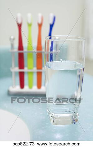 Assorted colorful toothbrushes and glass of water View Large Photo Image Stock Image - Assorted colorful toothbrushes and glass of water. Fotosearch